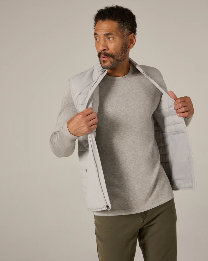 Man wearing a gray jacket over a gray shirt with a plain background