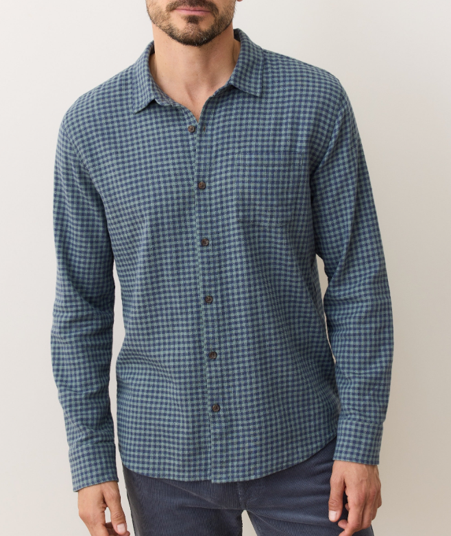 Man wearing a blue and green checkered shirt against a plain background