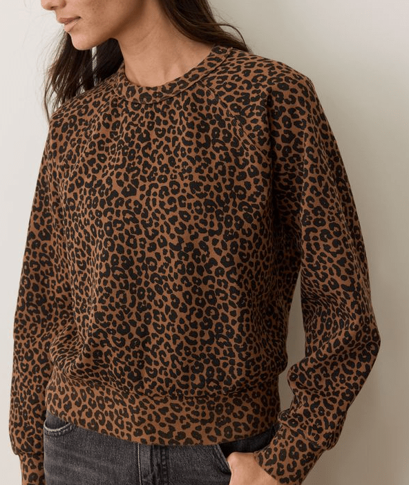 A woman wearing a leopard print sweartshirt on a white background
