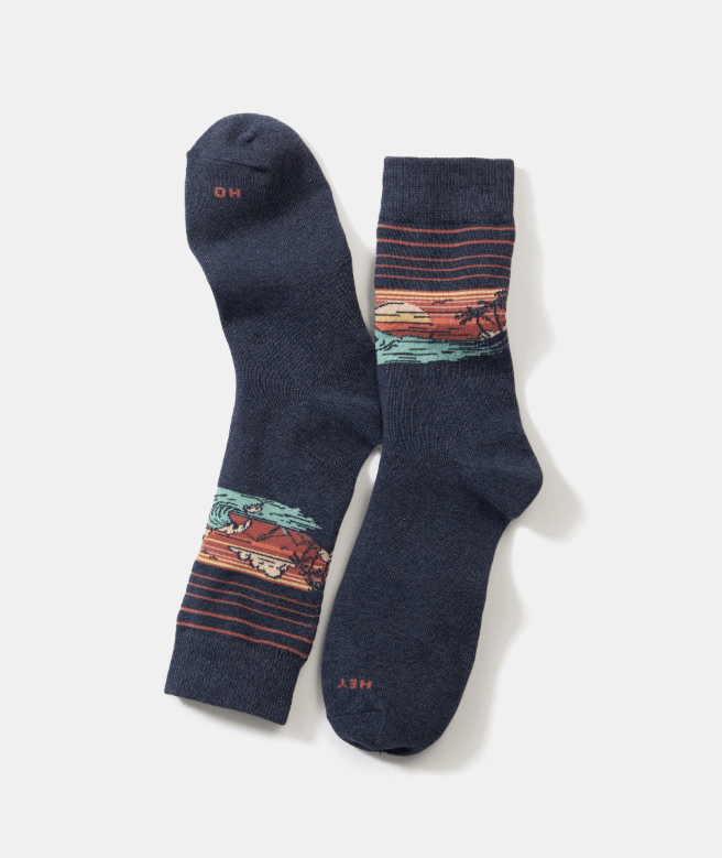 A pair of Men's navy socks with a sunset design on a white background