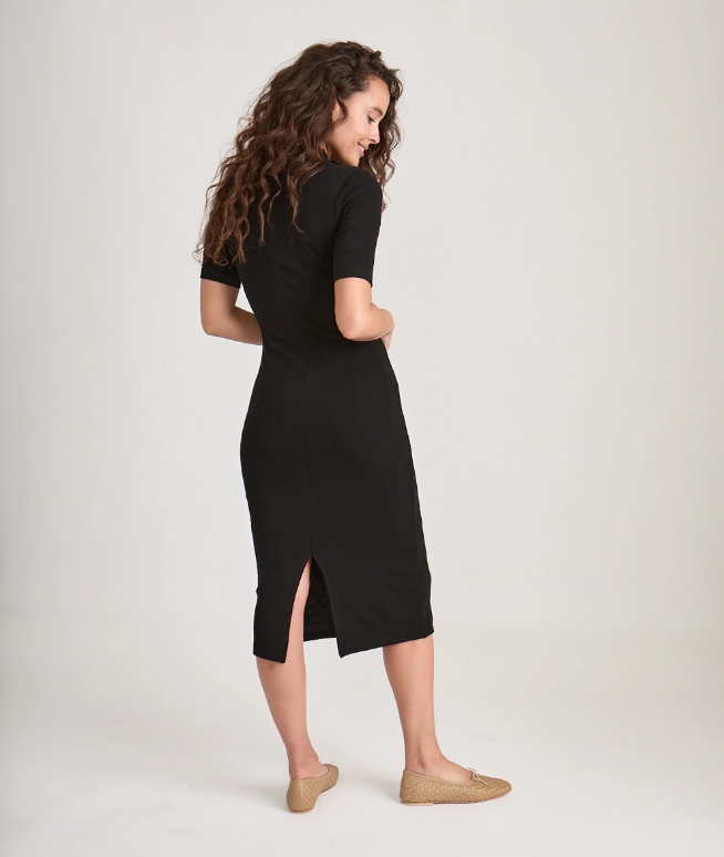 View from behind of a black ribbed shortsleeve mock neck midi dress.