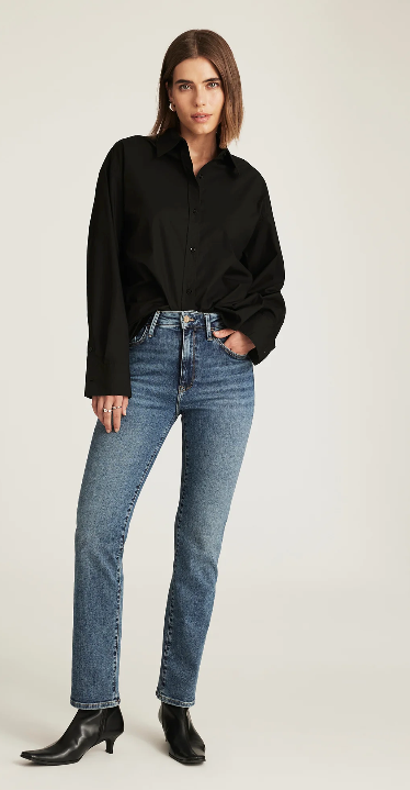 Woman wearing a black shirt and blue jeans on a white background