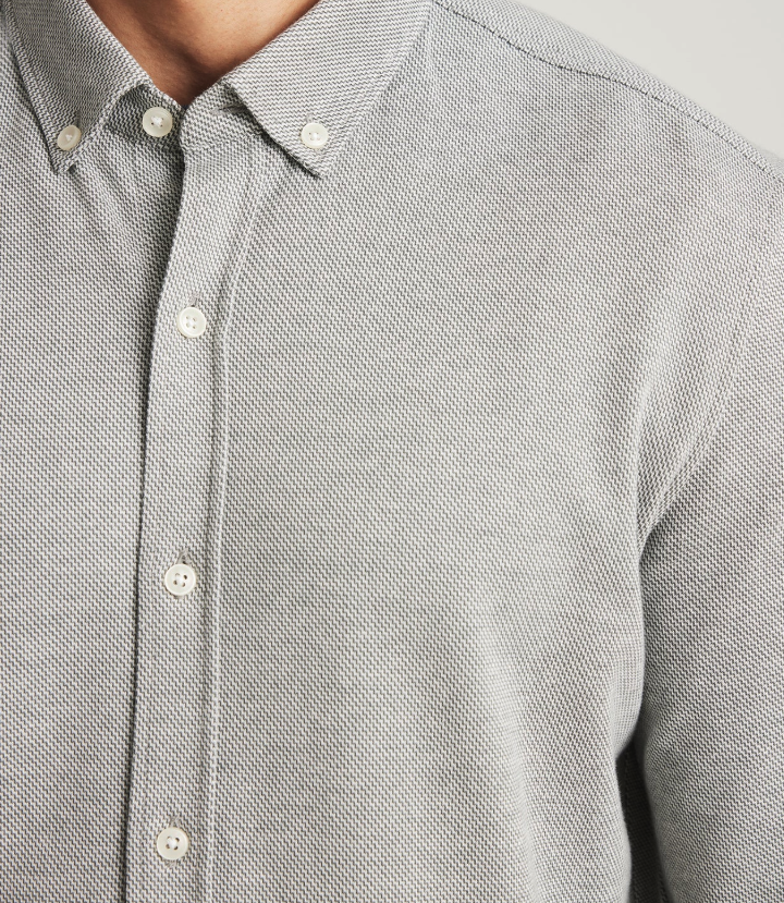 Close-up of a gray button-up shirt with a blurred background