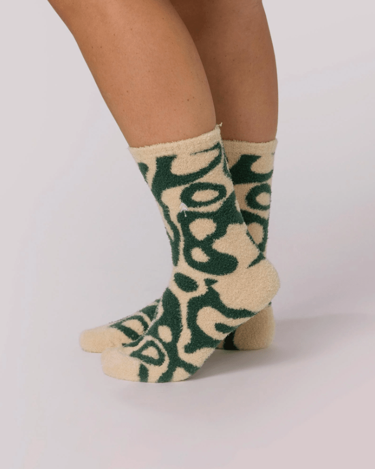 Beige and green patterned socks on a plain background