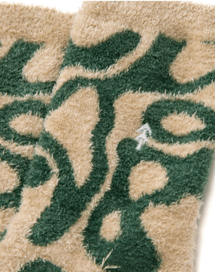 Close-up of textured socks with green leaf pattern on beige background