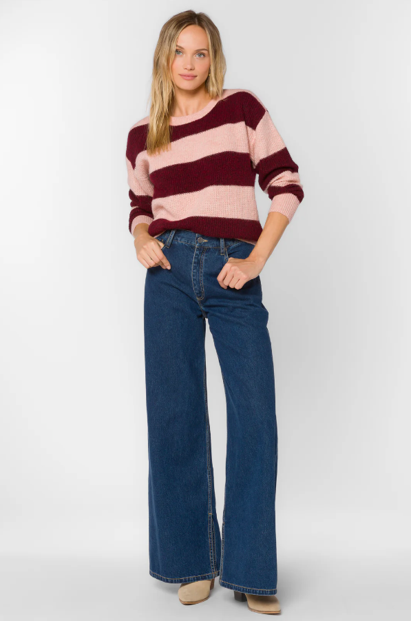 Woman wearing a striped sweater and jeans on a white background