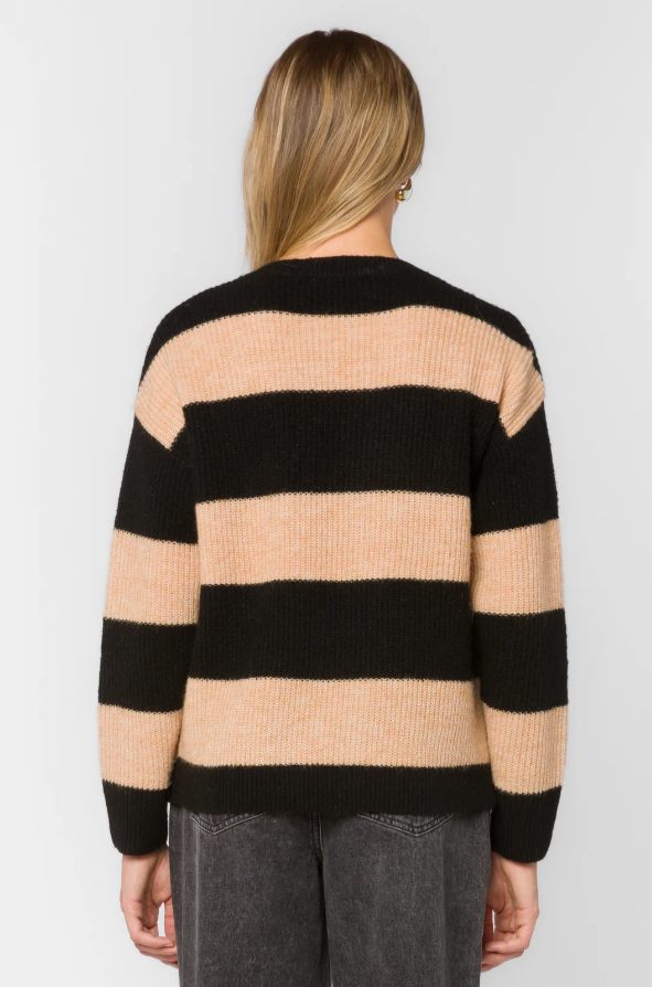 woman wearing a black and beige striped sweater on a white background