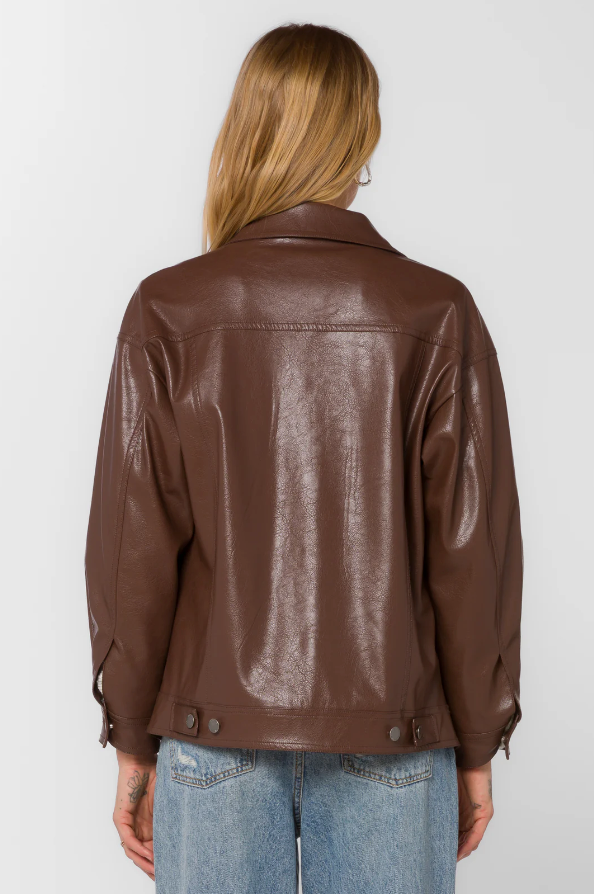 Woman wearing a brown faux leather jacket on a white background