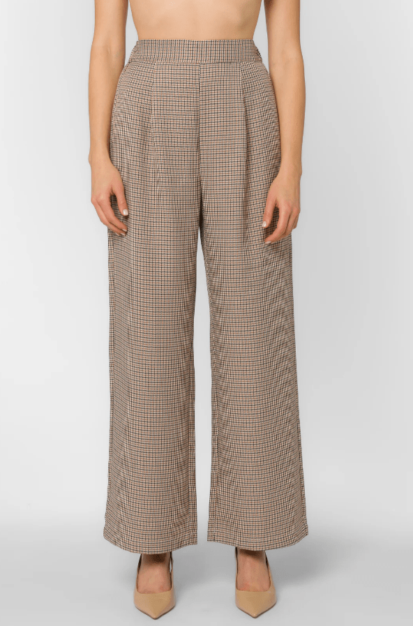 Woman wearing houndstooth pants on a white background