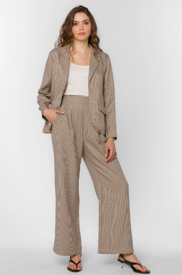 Woman wearing a brown houndstooth suit on a white background