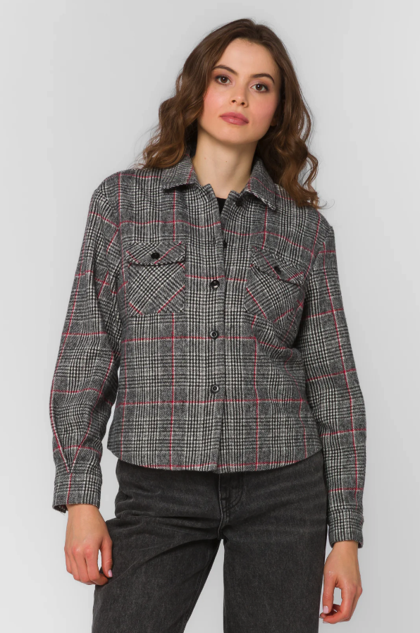 Woman wearing a checkered jacket against a plain background