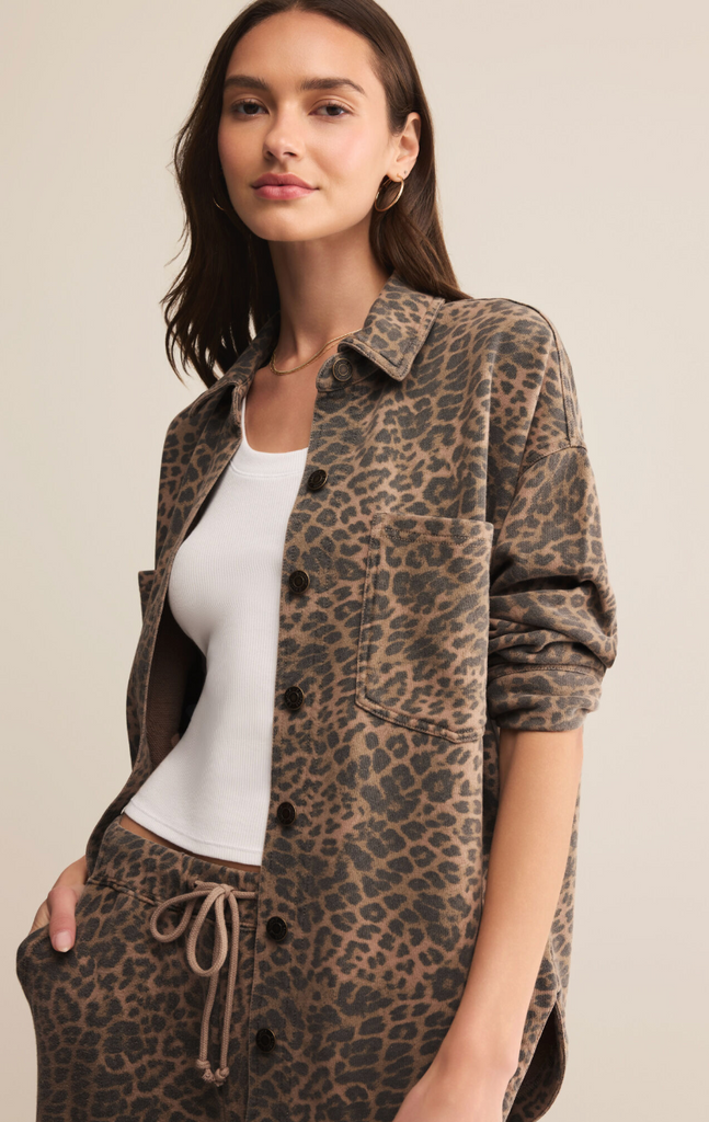 Woman wearing a leopard print shirt and pants on a beige background