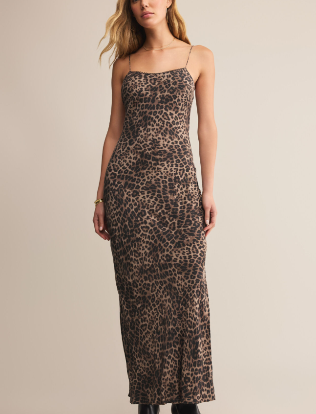 Woman wearing a leopard print midi dress against a plain background