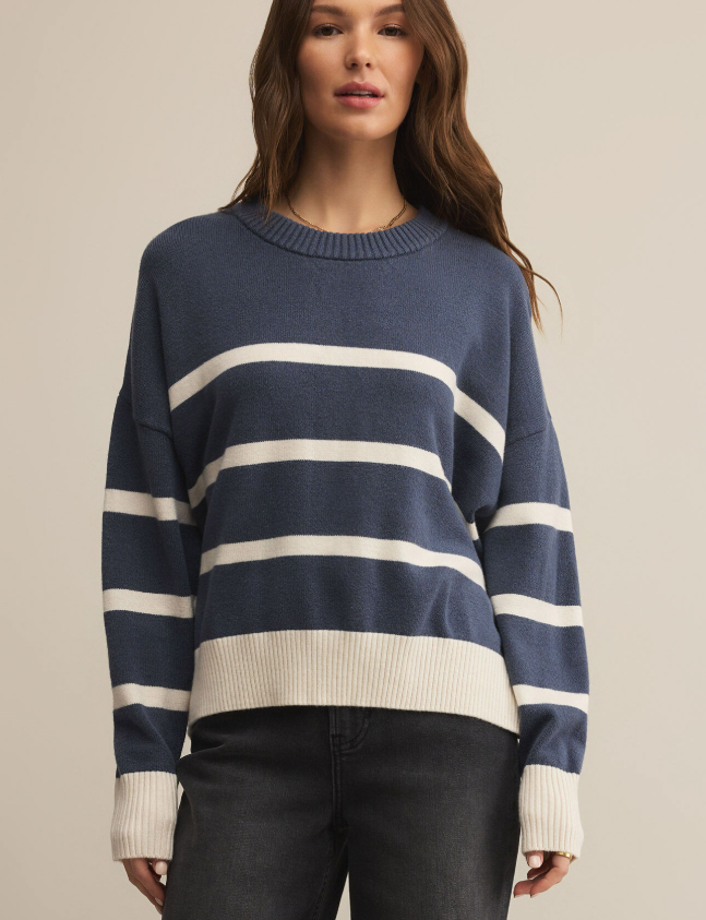 Woman wearing a navy and white striped sweater against a beige background